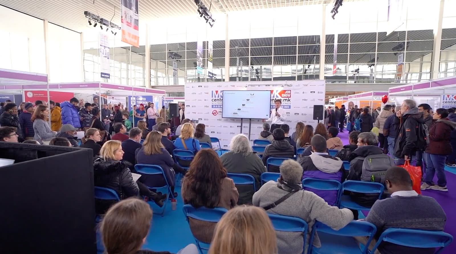 A speaker presenting to an engaged audience at an MK Job Show talk
